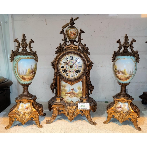 492 - A 19th century French 3 piece clock garniture in ornate gilt metal and porcelain decorated with rura... 