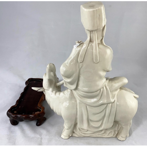 159a - A Chinese blanc de chine group, man sat on cow, on wooden stand, full height 33cm (cow head a.f.)