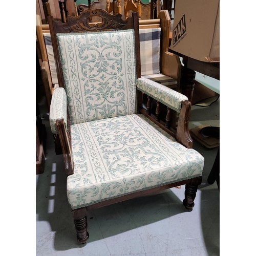 560 - An Edwardian armchair with carved frame, reupholstered in cream/green patterned fabric