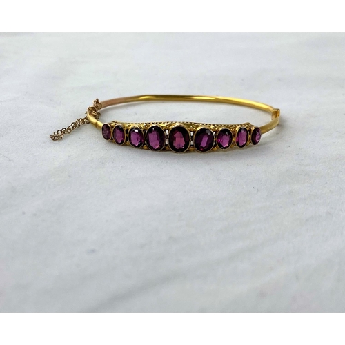 296 - An Edwardian 9 carat hallmarked gold hinged bracelet set 9 graduating oval amethysts, 5.1 gm (minor ... 