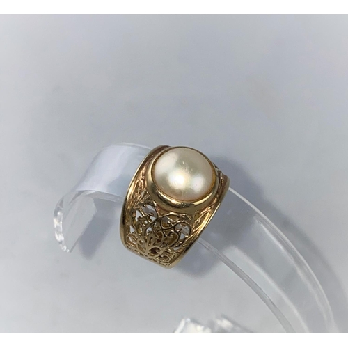 299 - A large pearl set dress ring with extensively pierced shoulders, stamped '9ct', size R-S, 6.5 gm