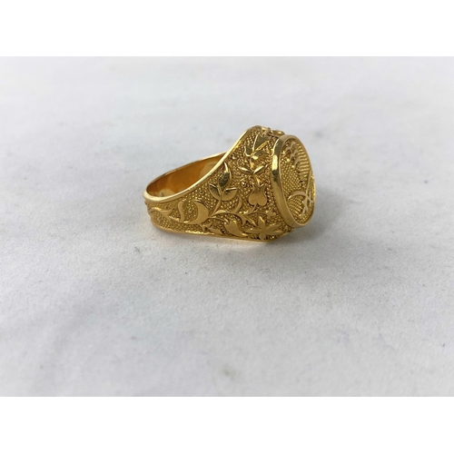 303 - A large yellow metal dress ring with motif of Saudi Air Force crossed swords and palm tree, unmarked... 