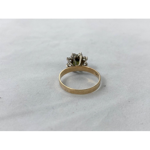305 - A 1970's dress ring set green topaz surrounded by clear stones in flower head setting, stamped '9ct'... 