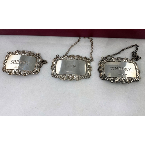 331 - Three hallmarked silver bottle labels; 15 in silver plate; 7 in china