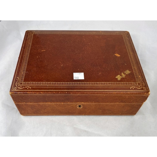 340 - A brown leather jewellery box with a selection of costume jewellery; Chinese coins; etc.