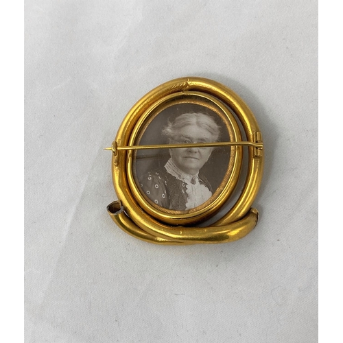 352 - A Victorian gilt metal oval brooch with central swivel double sided photo miniatures