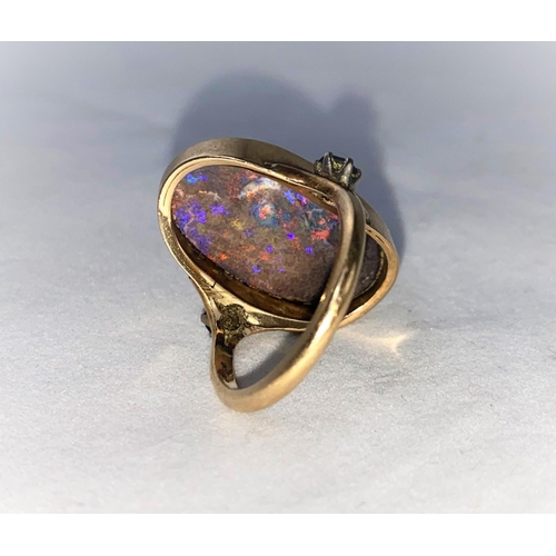 375 - A yellow metal dress ring set large oval black opal coloured stone, flanked by 2 green stones, stamp... 