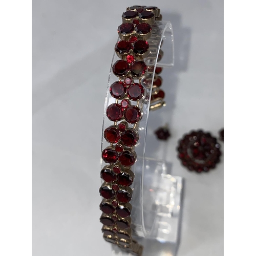 396 - A late Victorian/Edwardian suite of garnet jewellery:  double row bracelet, circular tiered brooch a... 