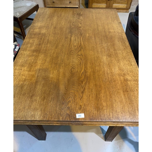 492 - A 1930's golden oak dining table with rectangular draw leaf top, on square legs, length 122