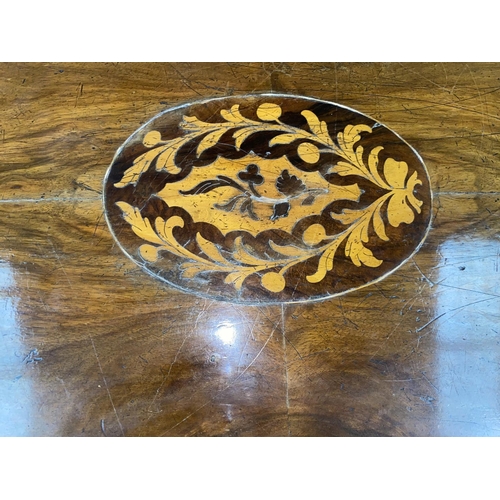 537 - A Victorian inlaid walnut looe table with oval top, on turned carved column and 4 splay feet