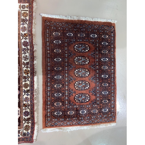 559 - A modern hand knotted Persian rug with brown ground, length 148 cm; a similar smaller rug