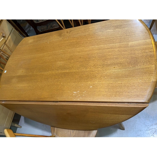 603 - A 1960's Ercol light elm dining suite comprising drop leaf circular table, 5 stick back chairs and s... 