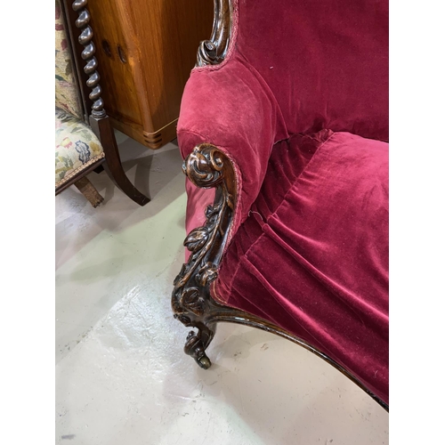 609 - A Victorian rosewood framed chaise longue with foliate carved rails and uprights, on scroll carved s... 