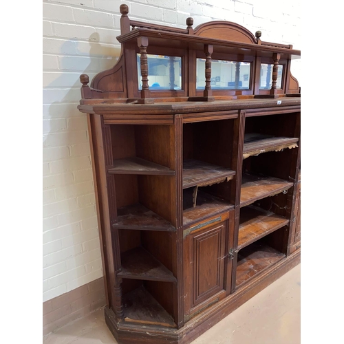 646 - An Edwardian large bookcase/side cabinet with low raised mirror back, 4 canted shelves to each corne... 