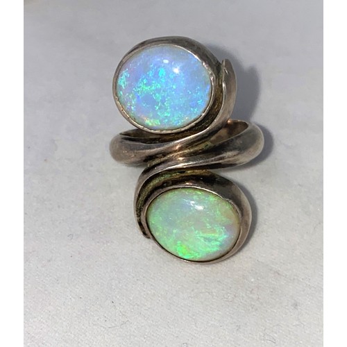 376 - A 1960's/70's modernist yellow metal dress ring with elliptical opal coloured stone and small blue s... 