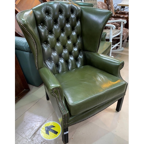 509 - A pair of gentleman's leather wing back armchairs with deep button backs, studded borders in green, ... 