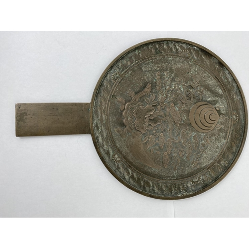 143 - A Japanese bronze hand mirror decorated with turtle and Kanji characters, length 34cm