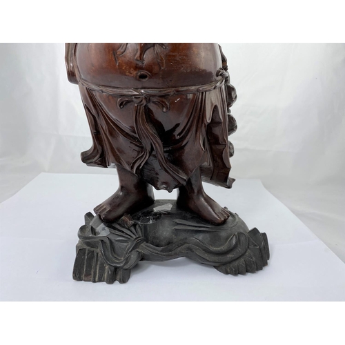 148 - A Chinese carved wooden figure of smiling buddha with raised arms, on ebonized base, height 38cm and... 