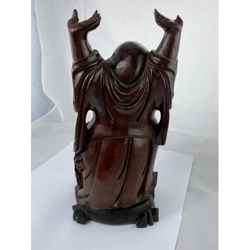 148 - A Chinese carved wooden figure of smiling buddha with raised arms, on ebonized base, height 38cm and... 