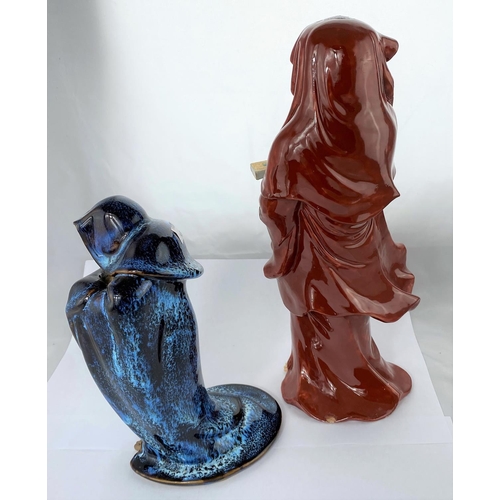 149 - Two Oriental ceramic figures of men in cloaks, one with red glaze, the other mottled blue and brown,... 