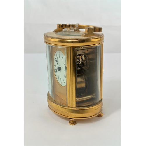 465 - A modern carriage clock in oval case with circular enamelled dial and timepiece movement, height 11 ... 