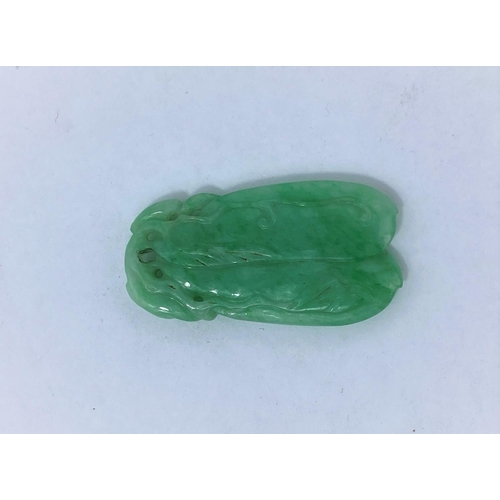135B - A Chinese light green jade coloured pendant in the form of two pieces of fruit