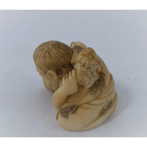 175 - A Japanese netsuke, man reclining with frog on back, missing one arm