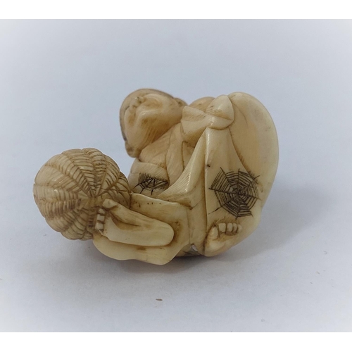 175 - A Japanese netsuke, man reclining with frog on back, missing one arm