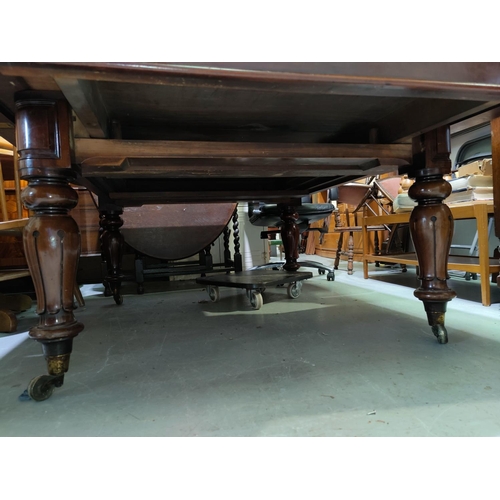 546 - A Victorian rounded rectangular mahogany extending dining table with 1 spare leaf, on turned and car... 