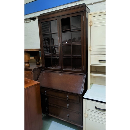 667 - A 1930's oak bureau bookcase with twin glazed doors over fall front and 3 drawers, cabriole legs (2 ... 