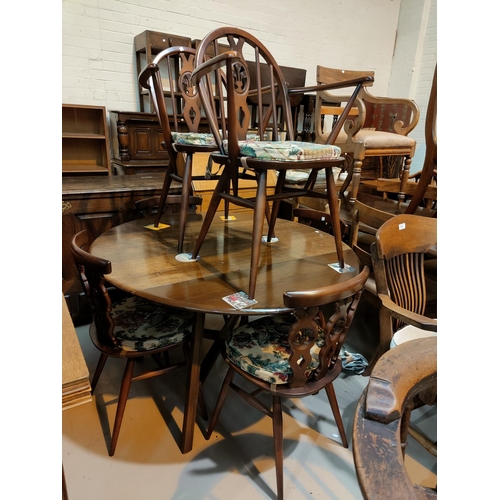 600 - An Ercol dark oak dining suite comprising drop leaf circular table and 4 fleur de lys chairs, 2 simi... 