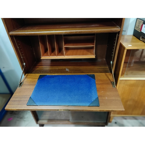 633 - A 1970's teak modular furniture writing desk/bookcase with sliding glass doors, 76 cm