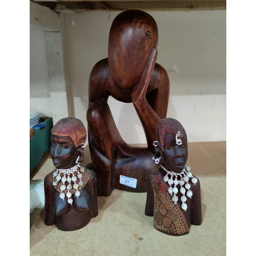 31 - A carved wood figure of 'the thinking man' and a carved pair of African busts