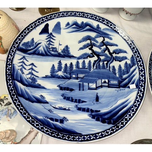 145 - A pair of large Japanese blue and white chargers with traditional country scenes, diameter 146cm