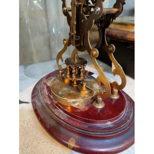 477A - A 400 day brass skeleton clock with silvered individual  numerals, under glass dome on mahogany plin... 