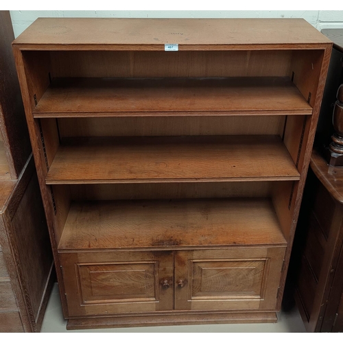 487 - An oak Arts & Crafts style bookcase with double cupboard to base, height 127cm x depth 28cm x length... 