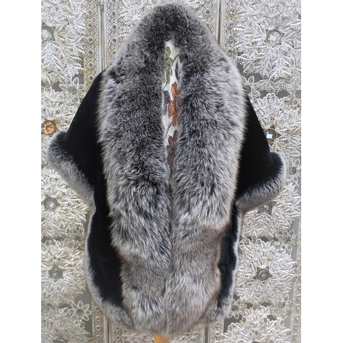 235 - A black evening shawl / cape with pockets and long black and white fur trim to edges