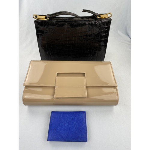 242 - An apricot patent clutch bag, a blue leather wallet, black patent 'crocodile' handbag (handle broken... 