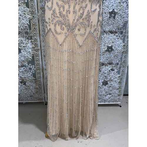 243 - A heavily beaded and sequinned sleeveless evening dress with apricot coloured stretch lining and net... 