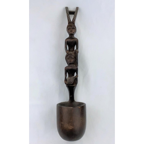 165 - An African carved wood ladle with tall figure handle, 47cm