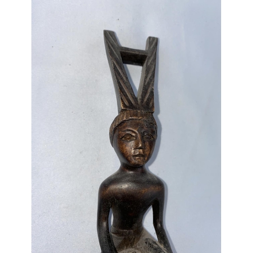 165 - An African carved wood ladle with tall figure handle, 47cm
