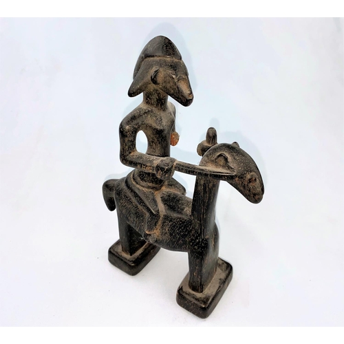 167 - An East African tribal carved wood figure of a man on horseback, applied black stain finish, possibl... 