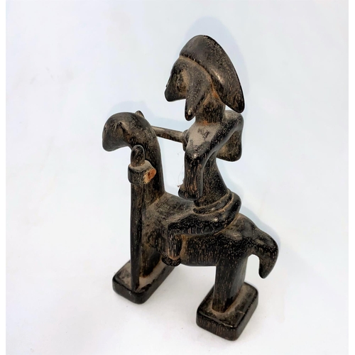 167 - An East African tribal carved wood figure of a man on horseback, applied black stain finish, possibl... 