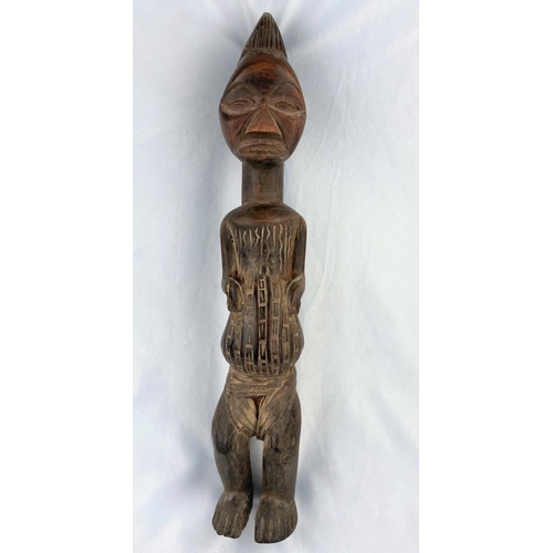 169 - An African tribal carved wood figure of a man, shallow carved geometric decoration, applied fabric l... 