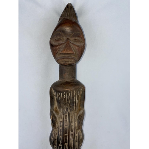 169 - An African tribal carved wood figure of a man, shallow carved geometric decoration, applied fabric l... 