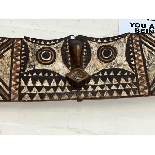 184 - An East African tribal carved wood hawk mask, Bwa shallow carved geometric decoration painted in ear... 