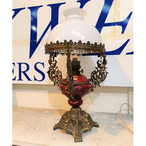 34 - An ornate table oil lamp in red pottery and cast brass