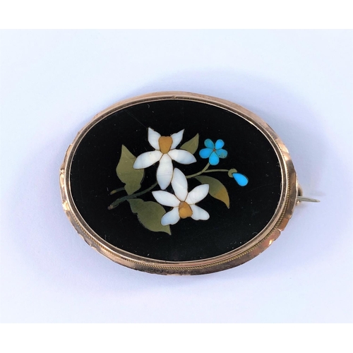 364 - A vintage Pietra-Dora brooch showing blue and white flowers in a plain oval surround testing 9ct