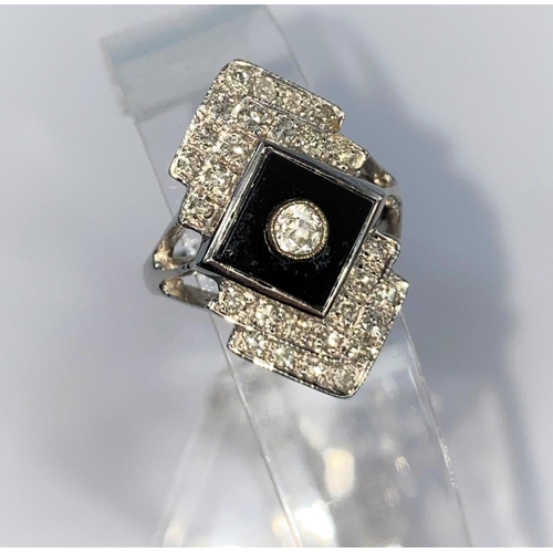 366 - An Art Deco style diamond and black onyx ring in 18ct (stamped) white gold, comprising of a diamond ... 