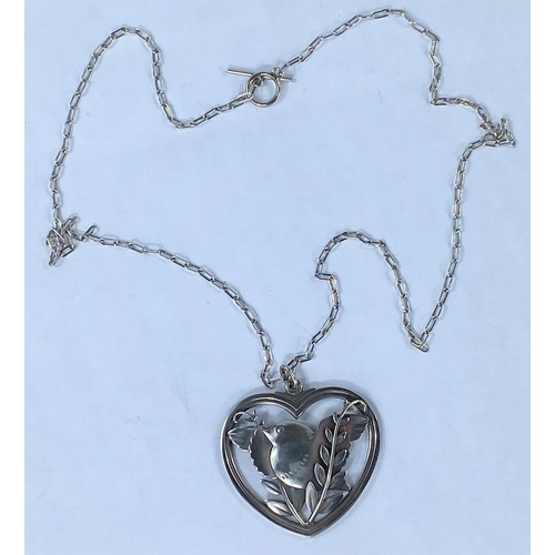291 - Georg Jensen, a heart shaped silver pendant with inset bird with outstretched wings perched on a bra... 
